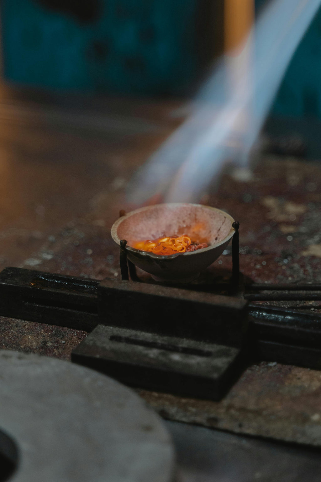 Small fire burning in a metal container on a stove