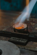 Small fire burning in a metal container on a stove